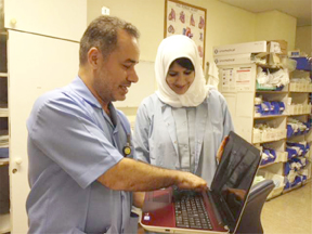  ICU staff Basil and Salima check out the new laptop for staff professional development and training purposes.