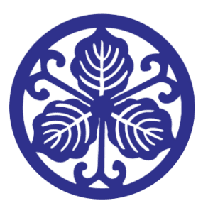 Circular navy blue Japanese mon crest logo for Tokyo Taro restaurant, featuring a stylised leaf pattern, at Al Falaj Hotel, Muscat