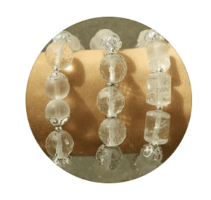 Three crystal bead bracelets in clear and frosted white tones displayed on a wooden stand, from Yatra crystal jewellery, Al Mouj, Muscat