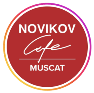 Circular red logo for Novikov Cafe Muscat with white lettering and a pink and orange gradient border, at St Regis Al Mouj Muscat, Al Mouj, Muscat