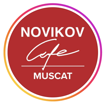 Circular red logo for Novikov Cafe Muscat with white lettering and a pink and orange gradient border, at St Regis Al Mouj Muscat, Al Mouj, Muscat