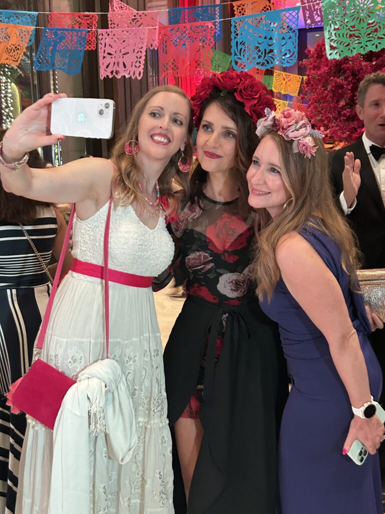Three WGO members taking a selfie at the WGO Fiesta ball 2025